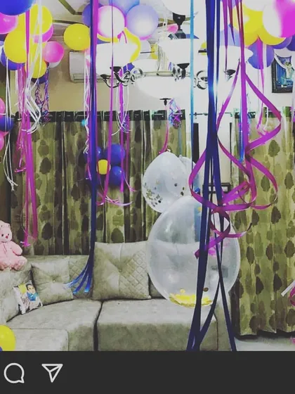 A fun and vibrant multi-color balloon decoration for a lively birthday party at home. I filled the living room ceiling with colorful balloons and long, curly ribbons.
