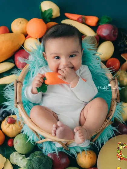 Munching on a carrot toy, this happy baby is the picture of health and joy. This is a great theme for introducing solids.