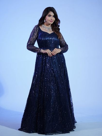 This full-length view of the navy blue sequin gown shows how it catches the light, creating a starry night effect. A true showstopper for any formal occasion.