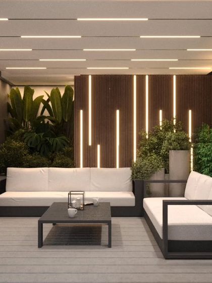 A luxurious indoor-outdoor seating concept with dramatic vertical lighting and lush plants.