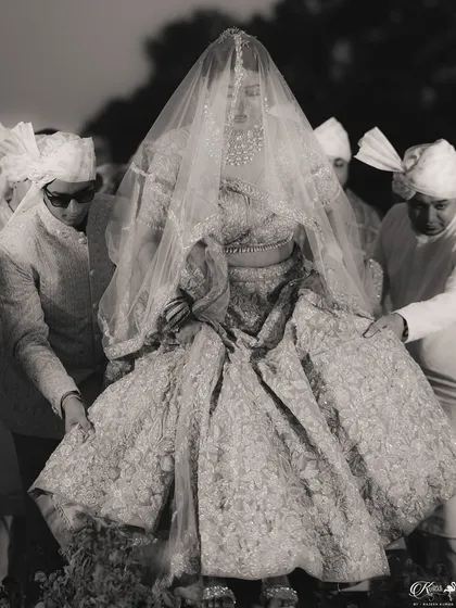 A timeless black and white shot of the bride being carried on a doli for her entrance.
