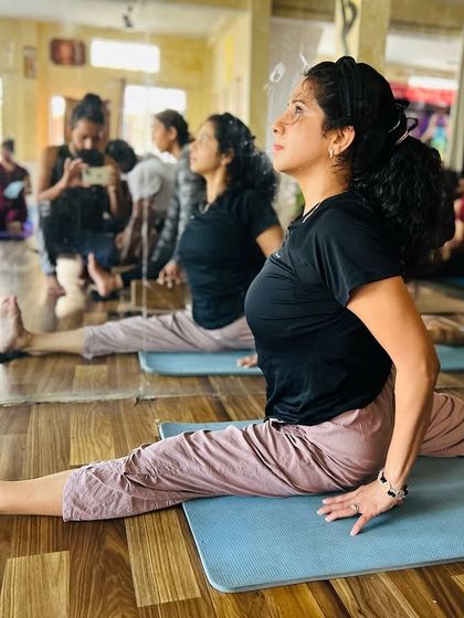 A student holds Hanumanasana with grace and focus. This is the result of consistent practice and patience.