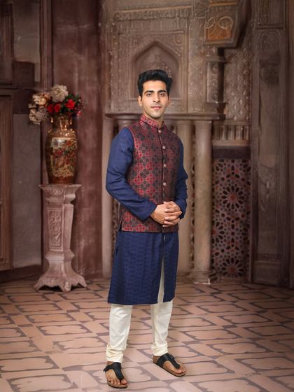 A classic look for any wedding function. This model wears a navy blue kurta paired with a contrasting red and blue printed Nehru jacket. It’s a versatile outfit perfect for a Sangeet or as a wedding guest.