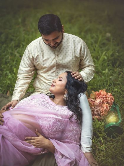 A tender moment of connection as he gently strokes her hair. This intimate shot captures the love and support between the couple during their outdoor maternity session.