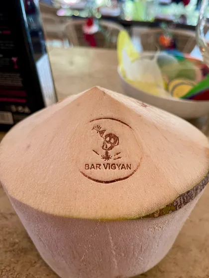 Our branding extends to every detail. Here, a fresh coconut, ready to be filled with a refreshing cocktail, is stamped with the Bar Vigyan logo for a personalized touch.