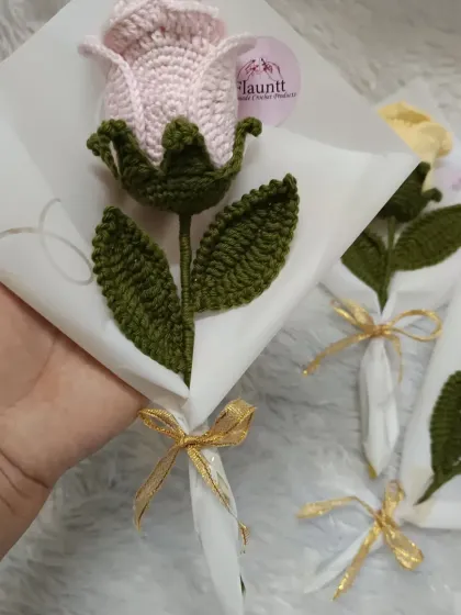A close-up of the light pink rose bouquet, wrapped in paper with a little gold ribbon. It's a simple but heartfelt gift.
