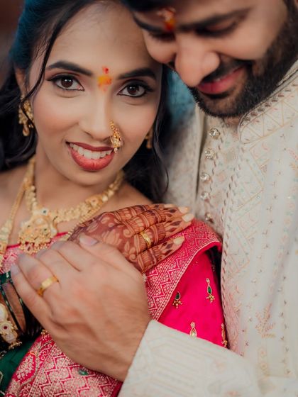 An intimate close-up of a Maharashtrian bride, her face adorned with a traditional bindi and nath. The photo focuses on her expressive eyes and the connection with her partner.