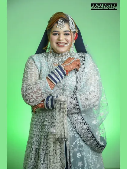 A bright, happy smile from the bride. This portrait captures her joyful spirit and the intricate details of her wedding dress, maang tikka, and nose ring.