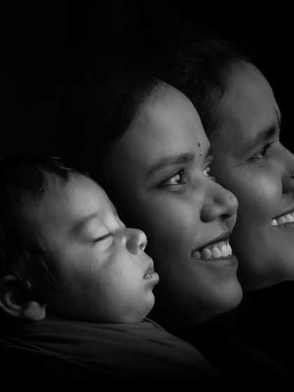 An artistic multiple-exposure photograph showing the profiles of a newborn, mother, and grandmother in a single frame.