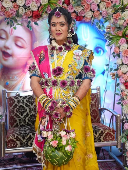 For this baby shower, I created a vibrant set using deep purple flowers and pearls. The full set, including the floral handbag, adds a beautiful pop of color against her yellow and pink saree.