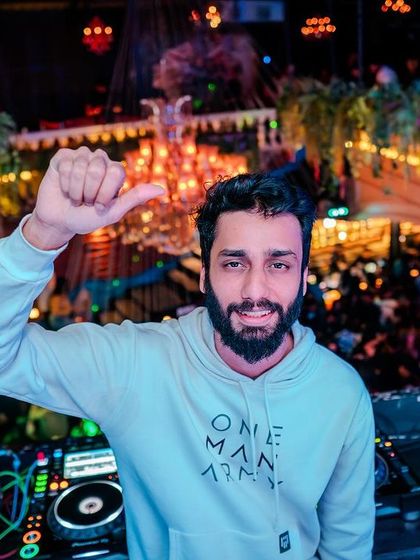 A selfie-style shot from the DJ booth, with the packed club visible below.