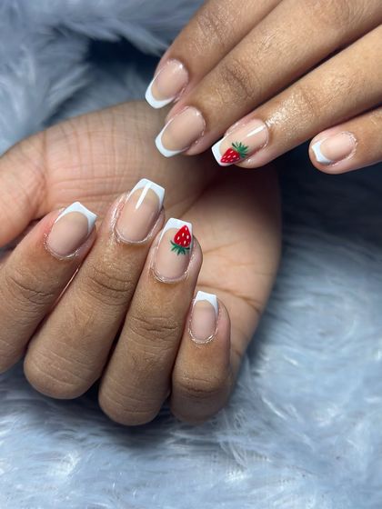 A classic French manicure with a sweet, hand-painted strawberry accent.