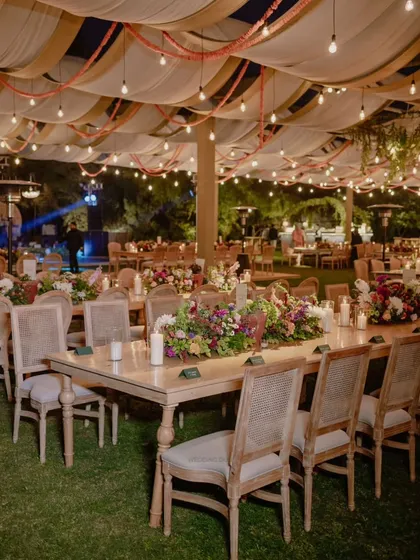 An evening reception designed to feel like a romantic night garden. We used long family-style tables, lush floral runners, and a canopy of draped fabric and string lights to create a warm and inviting atmosphere for dinner and conversation.