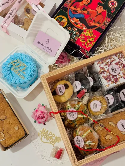 Here you can see my Rakhi Hamper 2 next to a custom "Happy Raksha Bandhan" bento cake. This hamper includes extra goodies like a rose pista cake tub and almond clusters for an even more decadent gift.