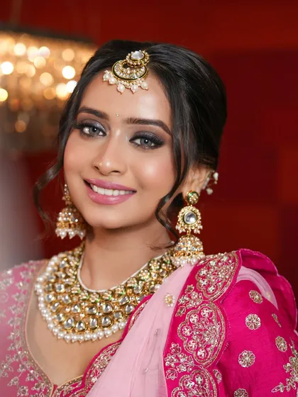 A classic bridal look is always timeless. Here, I created a soft yet defined smokey eye with a touch of sparkle, paired with a glowing skin finish and a beautiful pink lip to complement her stunning rani pink lehenga.