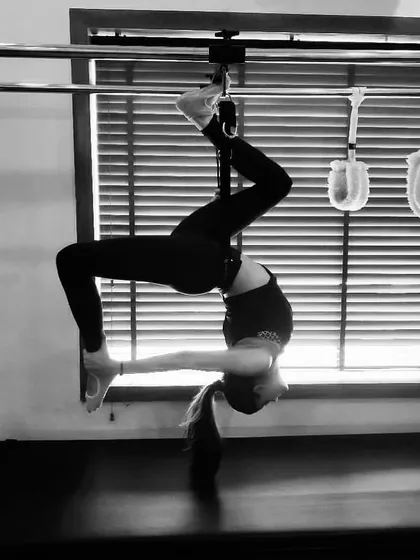 We work with you to achieve advanced postures like this inverted backbend on the Cadillac. This movement deeply stretches the spine and shoulders while requiring immense core and arm strength.