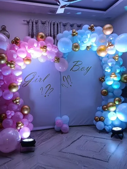 Building suspense for a gender reveal party with a "Girl or Boy?" theme. This backdrop uses distinct pink and blue balloon arches with spotlights to create a dramatic and exciting reveal moment.