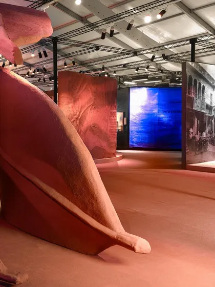 The 'Terra' installation seen in the context of the wider exhibition hall. The monumental leaves create a powerful focal point, drawing visitors into their earthy embrace.