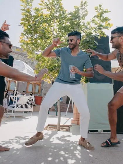The groom and his friends letting loose and dancing at the fun-filled pool party.