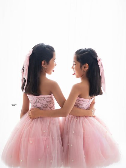 A little bit of sibling mischief. The sisters stick their tongues out at each other, a funny and authentic moment that perfectly captures the playful side of their relationship.