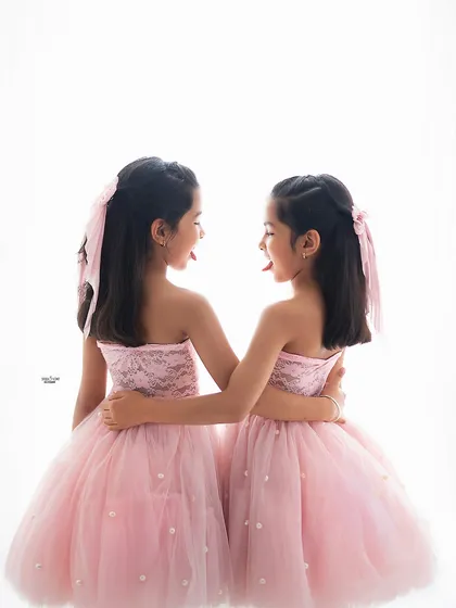 A little bit of sibling mischief. The sisters stick their tongues out at each other, a funny and authentic moment that perfectly captures the playful side of their relationship.