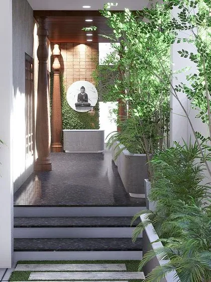 A view from the lushly planted entryway, looking towards the main door. The path is lined with greenery, creating a welcoming and natural transition into the home.