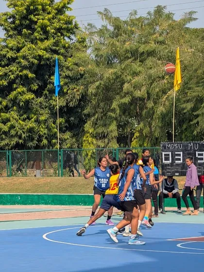 The game is in full flow. This action shot captures the intensity of the Mumbai University team during a competitive play, showcasing the fast-paced nature of inter-collegiate basketball.
