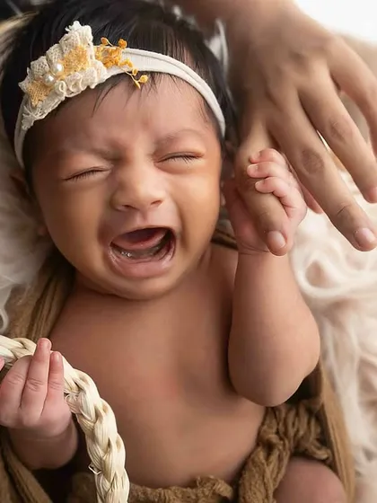 Even a little cry can make for a powerful and real photograph. This newborn's expression is full of emotion, a genuine moment captured in the studio.