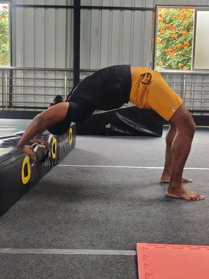 Using equipment to assist with flexibility drills, this adult student deepens his backbend.