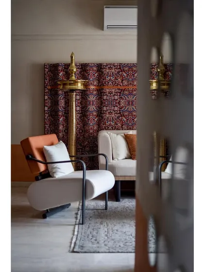Another angle of the living room, highlighting the custom Kalamkari art piece and the elegant, light-colored furniture.