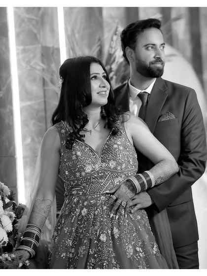 The same classic portrait in black and white, this time with a slightly different crop. It showcases the couple's elegant attire and their relaxed, happy connection.