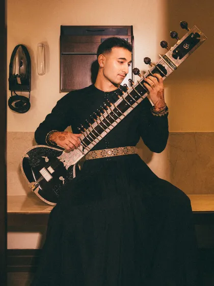 A candid moment in the green room, sitar in hand. Even the backstage moments have their own aesthetic.