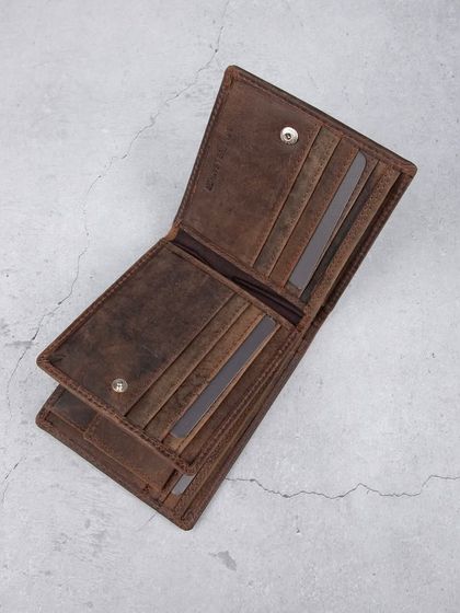 An overhead shot of the open distressed leather wallet, showing all its compartments.