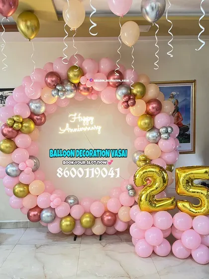 A soft and pretty 25th-anniversary setup featuring a full ring of pink, peach, and gold balloons. Large gold foil "25" balloons are placed at the base for a perfect photo opportunity.