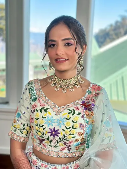 Another beautiful shot by the window. The natural light enhances the soft colors of her makeup and the intricate embroidery of her outfit.
