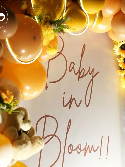 A close up of the "Baby in Bloom" backdrop, framed by a cheerful arch of orange and sunflower yellow balloons. This detail shot shows the warmth and happiness radiating from the honey bee theme.