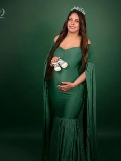 A regal portrait of a mom-to-be in our bottle green mermaid gown, complete with a crown. This dress is perfect for creating a powerful and elegant look, celebrating the queen that you are.