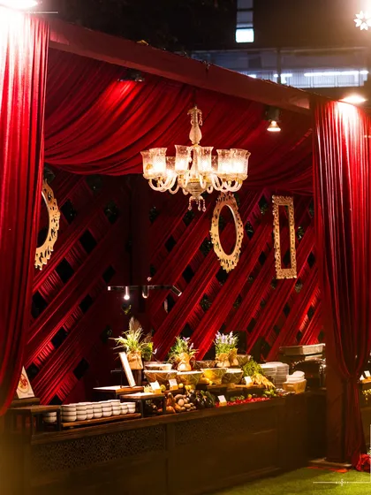 A dramatic red draped buffet station at an event in New Delhi. We design our setups to match the theme and decor of the event, creating a fully immersive experience.