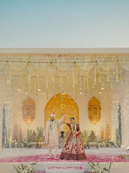 A mandap straight out of a dream. We designed this elegant stage with hanging floral strings and dramatic cold pyro effects for a truly grand Varmala entrance.