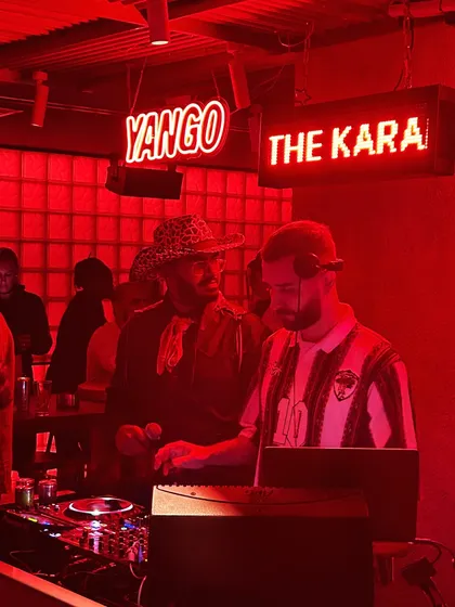 A red-lit DJ booth at a club in Dubai. I'm comfortable playing in any setting, from outdoor festivals to intimate, high-energy clubs.
