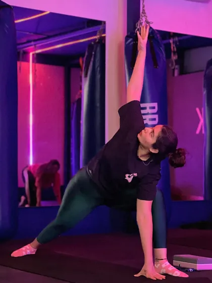 A client holds a perfect extended side angle pose on the yoga mat, working on her flexibility and strength in our studio with its unique lighting.