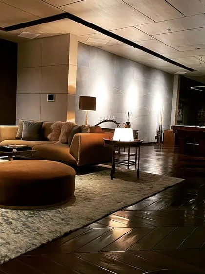 This living space was designed for sophisticated comfort, using a moody, layered lighting scheme. I employed wall washing to create a soft glow on the textured feature wall, combined with discreet track lighting and elegant table lamps to build an environment that is both intimate and luxurious.