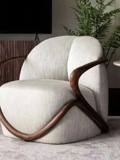 An inspiration image of a stunning accent chair with a sculptural, wrap-around wooden frame and light upholstery. If you love this style, send us a photo and we can build it for you.
