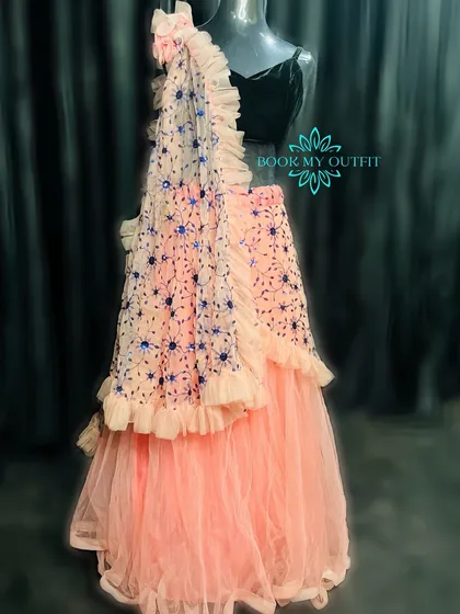 For a more modern look at a reception or sangeet, I have this beautiful peach ruffled lehenga. The tiered skirt and embroidered dupatta create a contemporary silhouette that is both elegant and easy to wear.