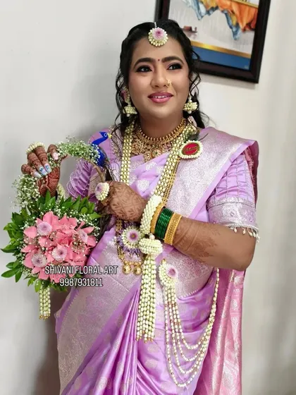 A full view of a mom-to-be wearing a complete dohale jevan set. She is holding a matching floral basket, a popular prop for photoshoots and carrying traditional offerings.