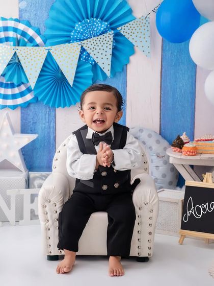 Dressed in his birthday best, this little gentleman is all smiles and claps, ready for his cake smash party to begin.