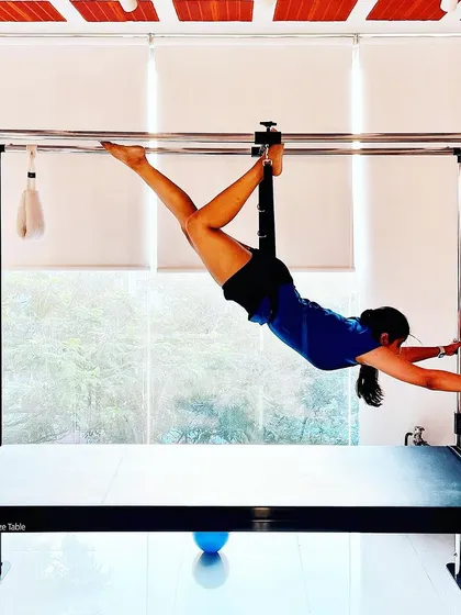 Your physical health is the canvas for your mind. This client demonstrates incredible strength and flexibility in this hanging pose on the Cadillac.
