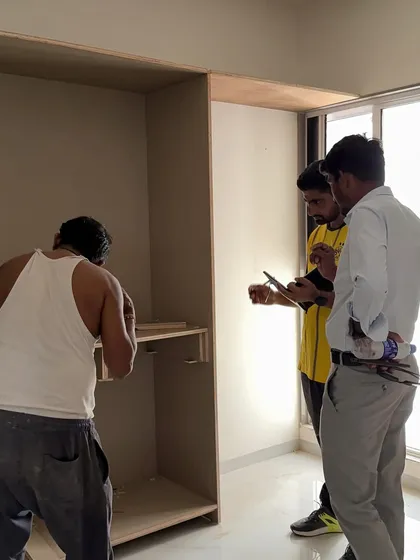 My team supervising the carpenter's work on a custom wardrobe.