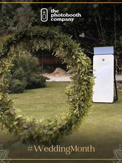 Our photo booth setup seamlessly integrated into a beautiful outdoor wedding decor. We work with your planners to ensure our booth complements your wedding's aesthetic, like this one with a rustic floral wreath.