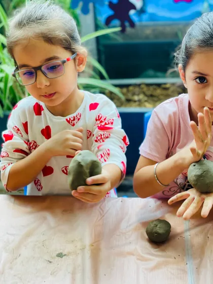 Almost there! These young sculptors are adding the final details to their clay Ganeshas before they are set aside to dry.